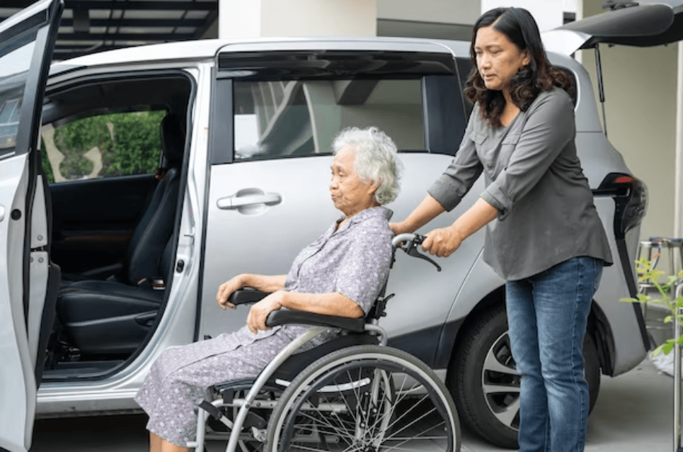 Elderly passenger being assisted into a wheelchair accessible vehicle